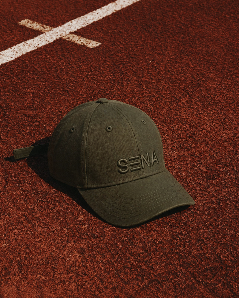 Green cap with 'Sena' logo on a red track surface