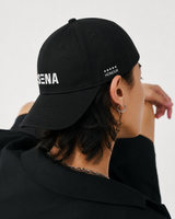 Person wearing a black cap with 'SENA' branding on a white background