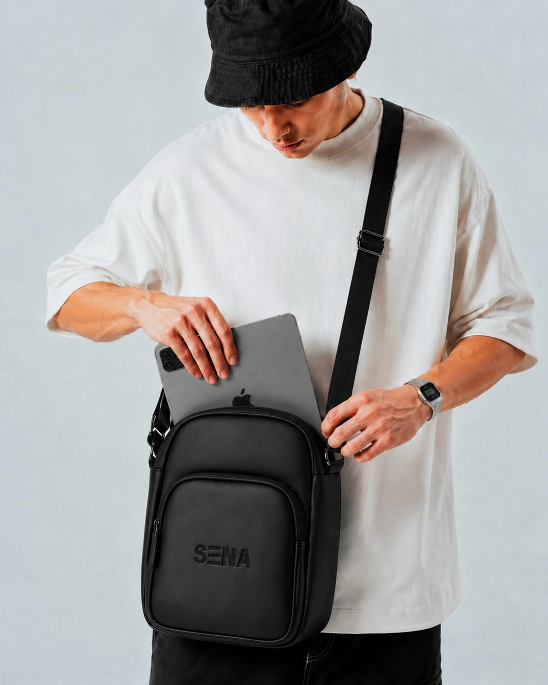Person holding a black Sena bag with a white background